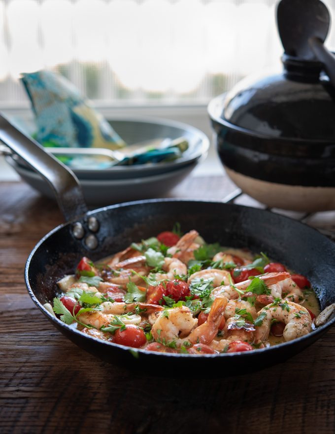 Shrimp and Tomatoes are cooked with Lemon Butter Sauce in a skillet.