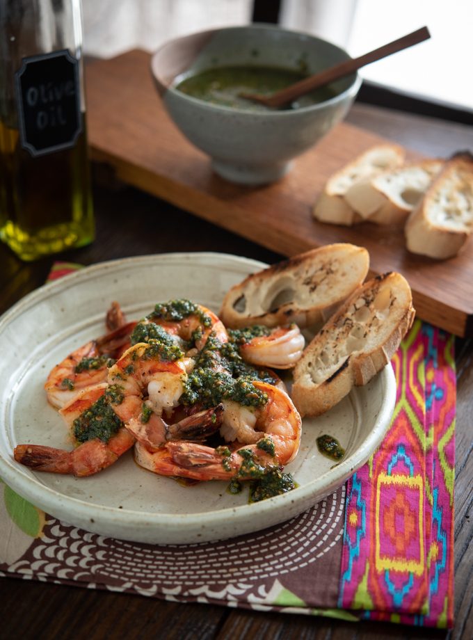 Mixed herb pesto made with mint and basil are topped over grilled shrimp