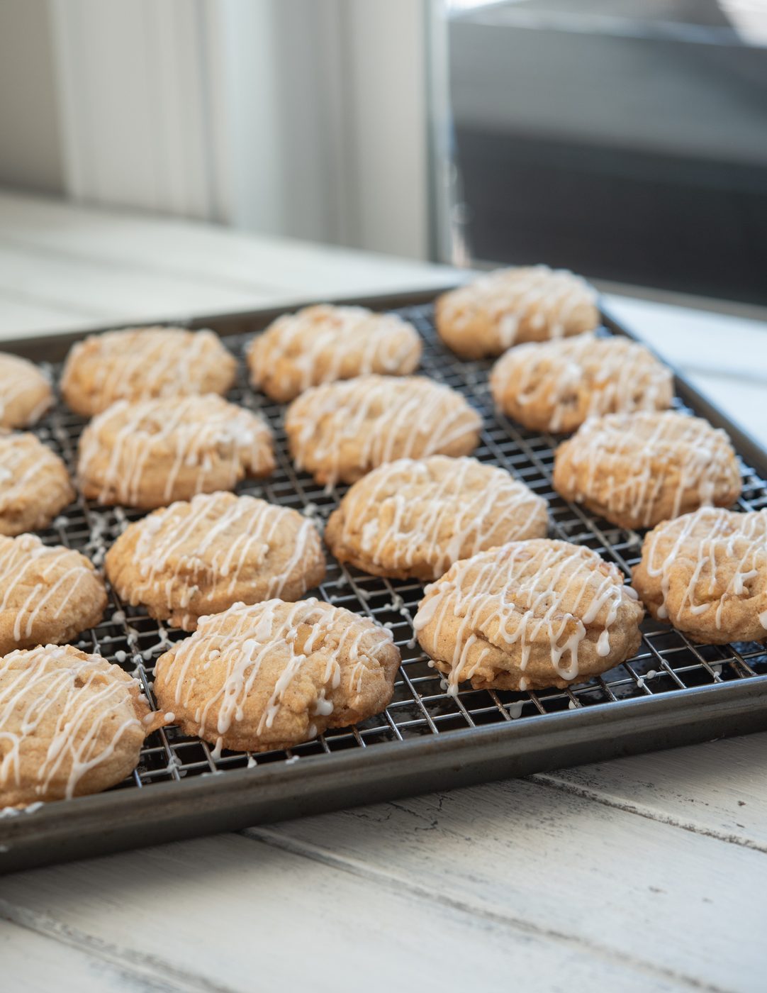 Iced apple cookies cooling on a wire rack