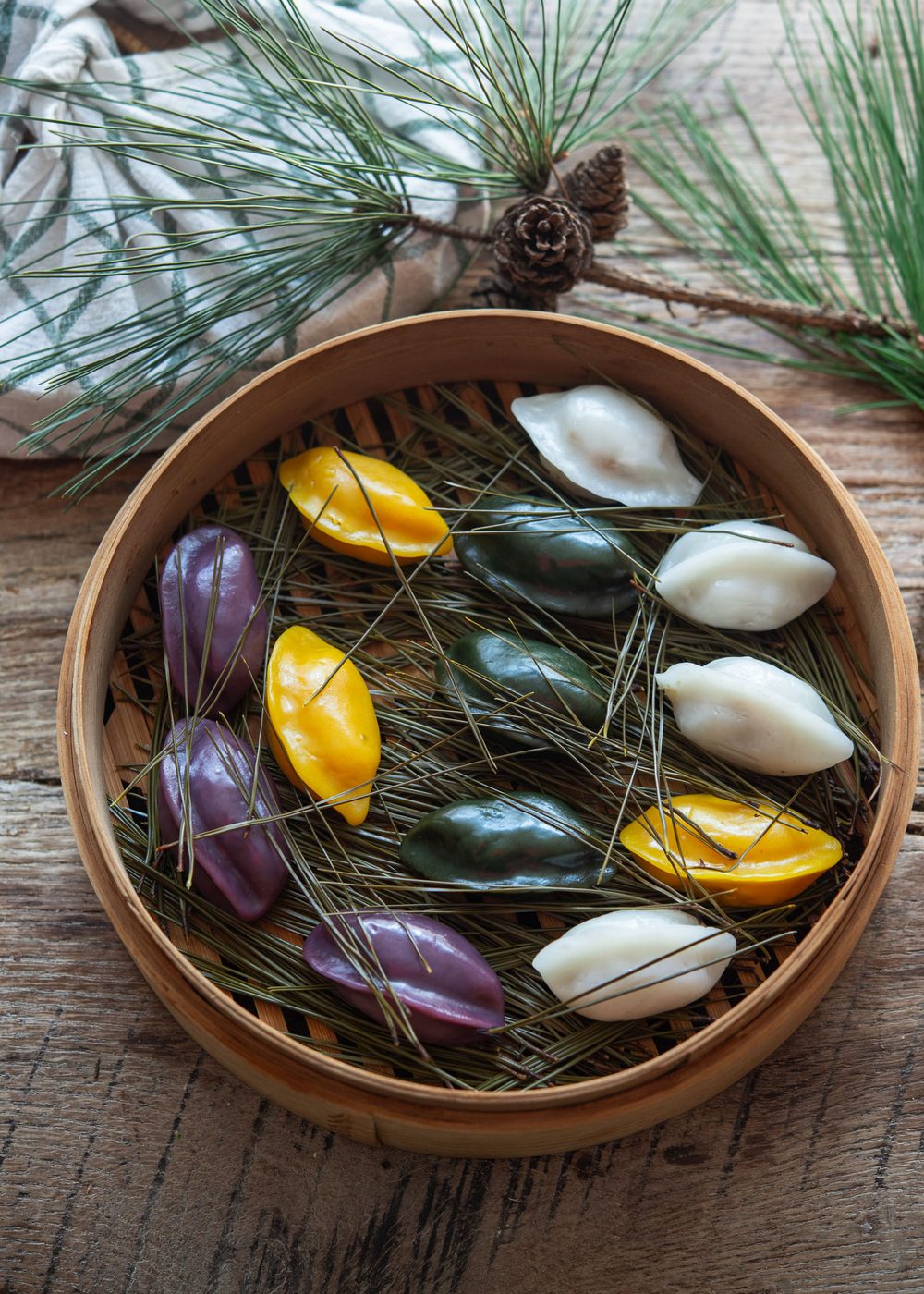 Colorful Songpyeon steamed over pine needles in a bamboo steamer
