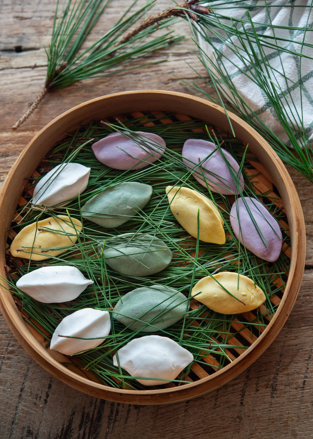 Songpyeon, Korean rice cakes for Chuseok, on pine needles in a bamboo steamer.