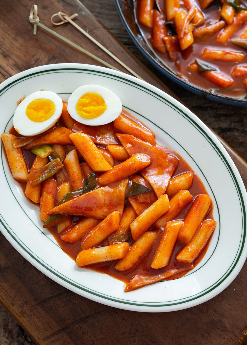 Spicy Korean tteokbokki with glossy red sauce and a hard-boiled egg on a plate