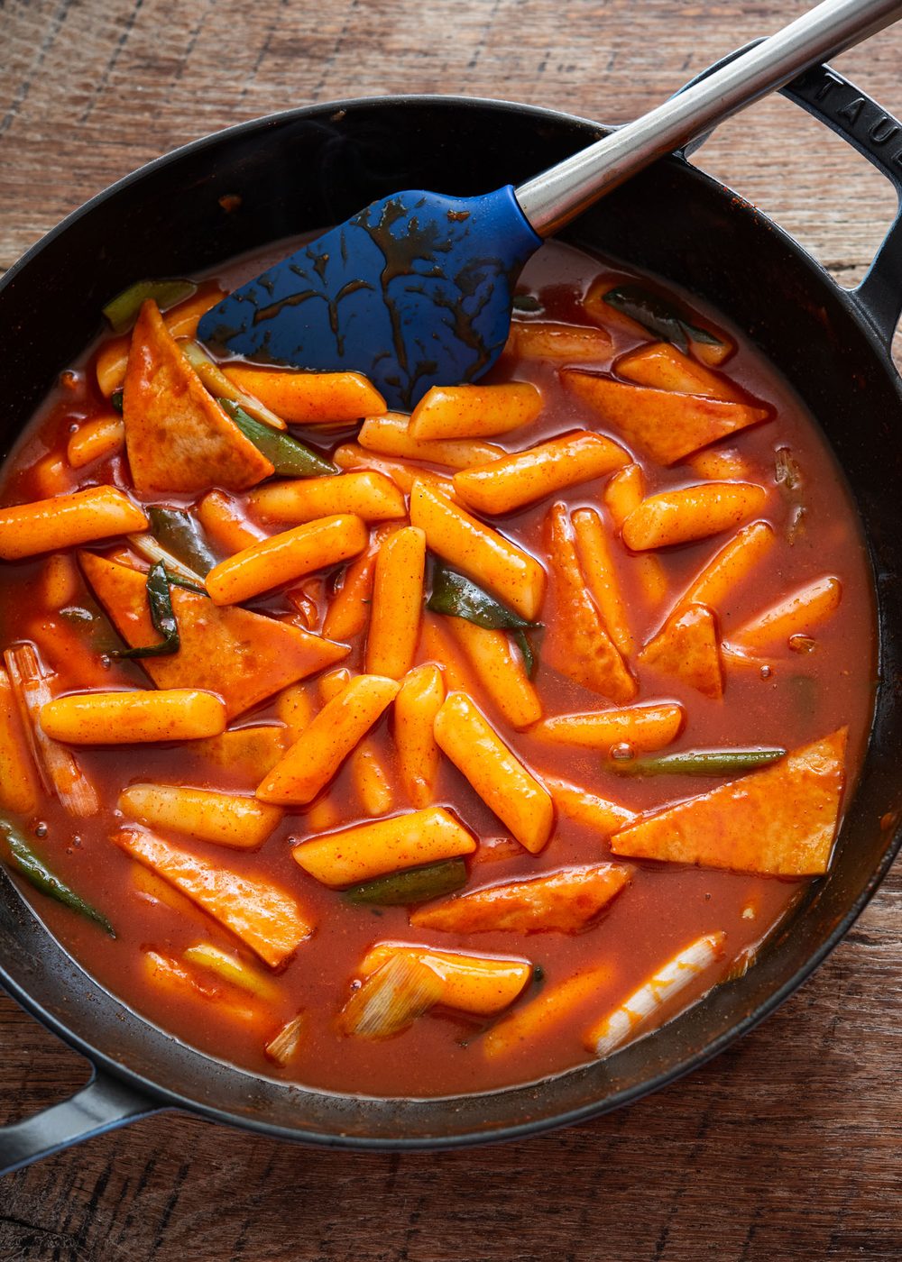 Tteokbokki, Korean spicy rice cakes, simmered in glossy red gochujang sauce in a skillet
