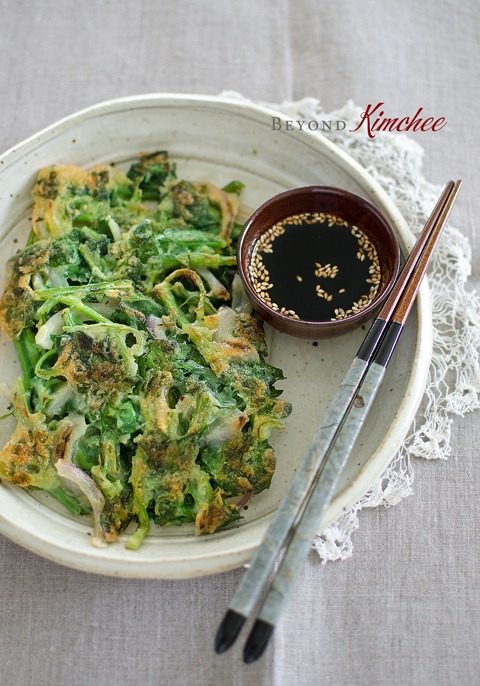 The crisp texture of spinach pancakes are served with a dipping sauce.