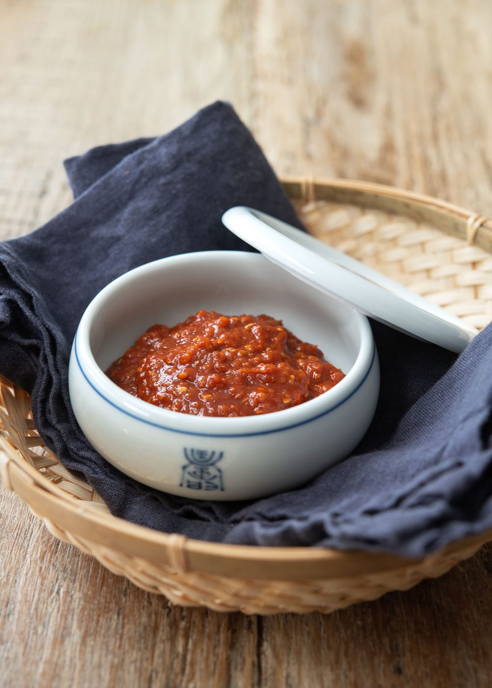 A bowl of ssamjang is presented with a lid on the side.