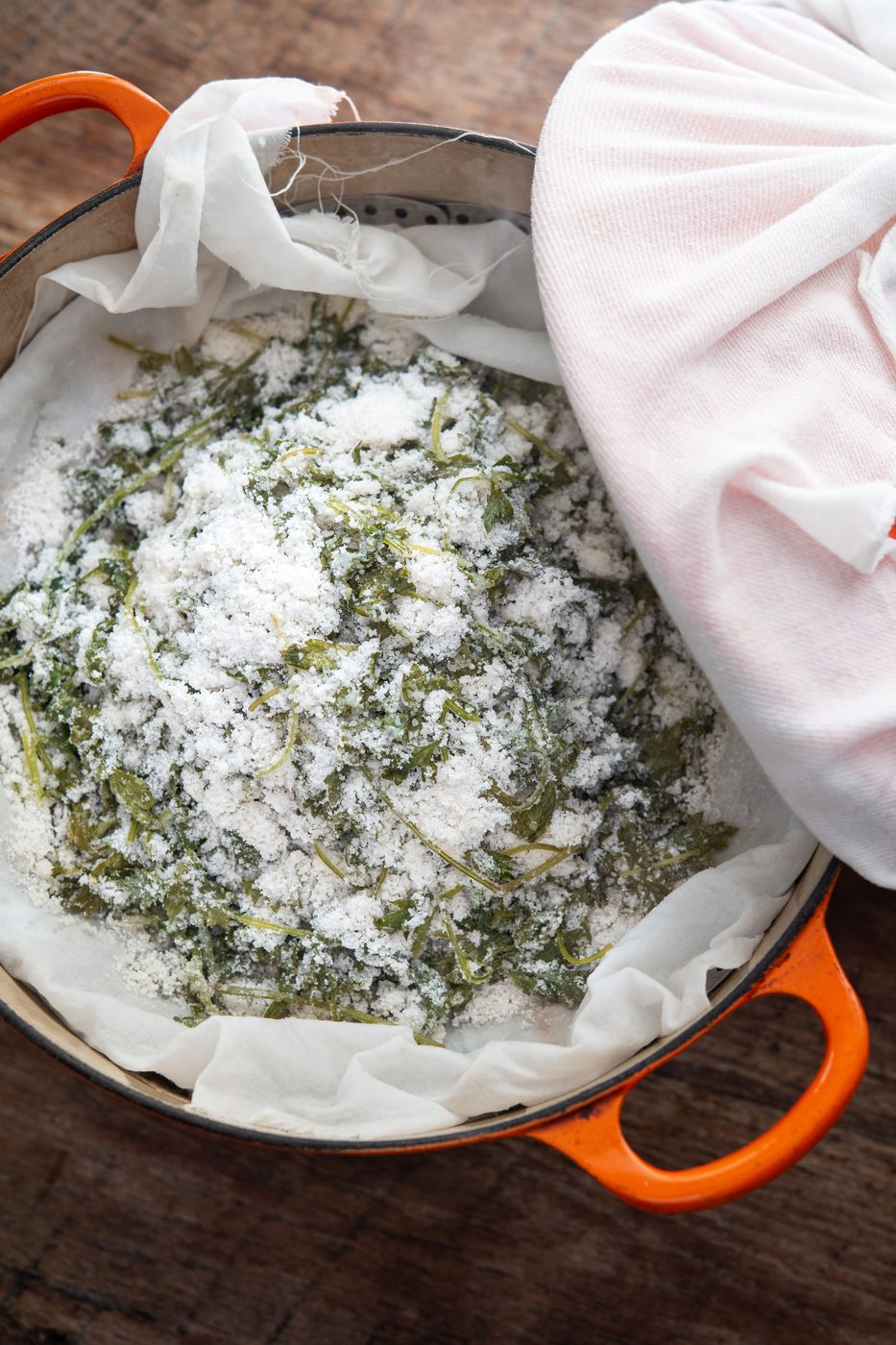 Steamed ssuk beomuri mugwort rice cake in a cloth-lined steamer in a pot