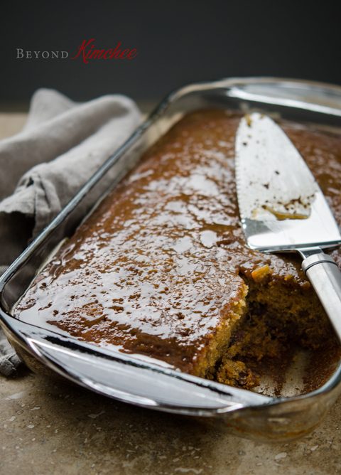 Sticky warm caramel sauce is poured on date pudding cake