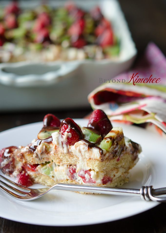 A slice of strawberry kiwi tiramisu is served on a plate.