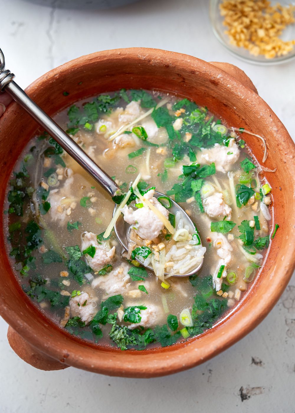 Thai chicken rice soup (Khao Tom Gai) in a bowl.