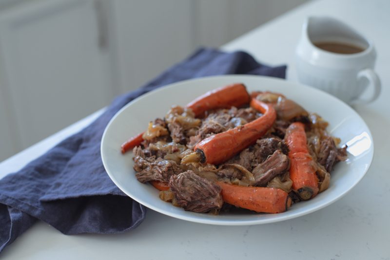 Dutch oven roasted beef and carrot is served in a platter.