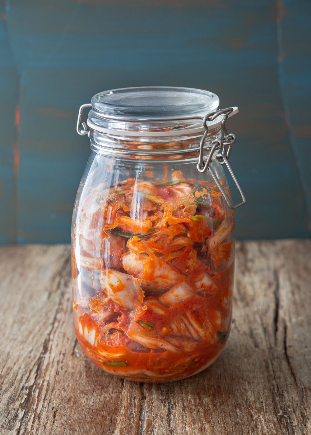 Vegan kimchi is stored and is fermenting in a glass jar.