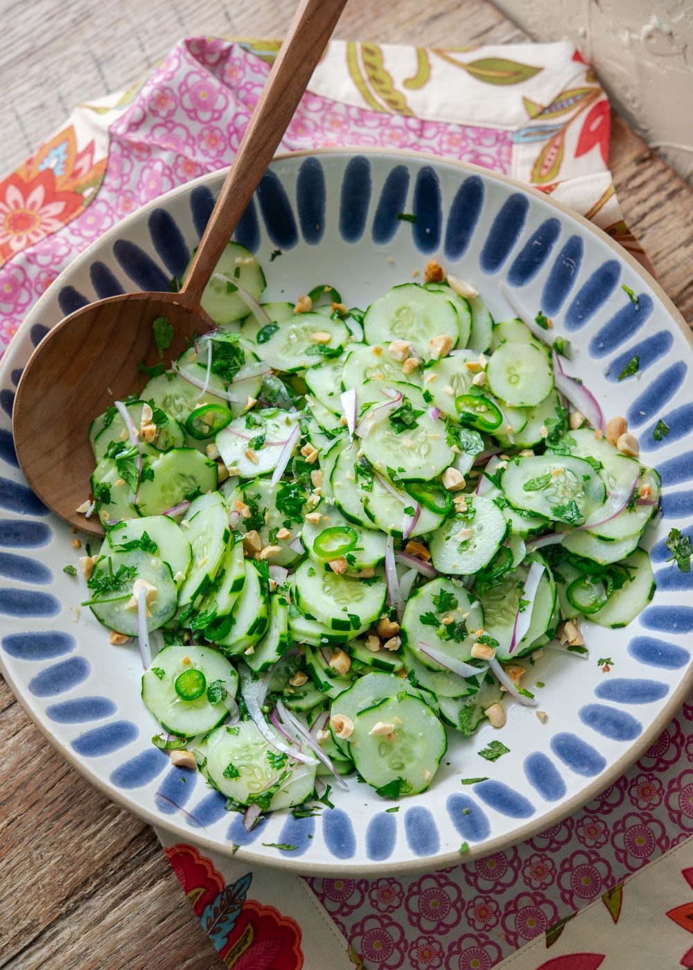 Vietnamese cucumber salad in a serving dish with wooden spoon.