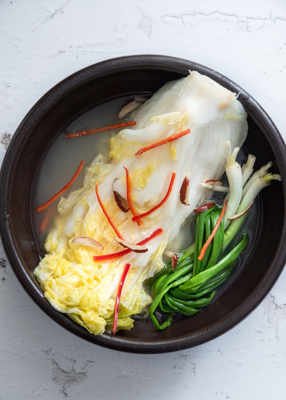White kimchi in a serving bowl.