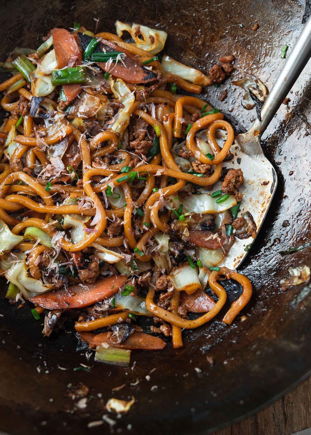 Stir-fried yaki udon noodles with pork and vegetables in a wok.