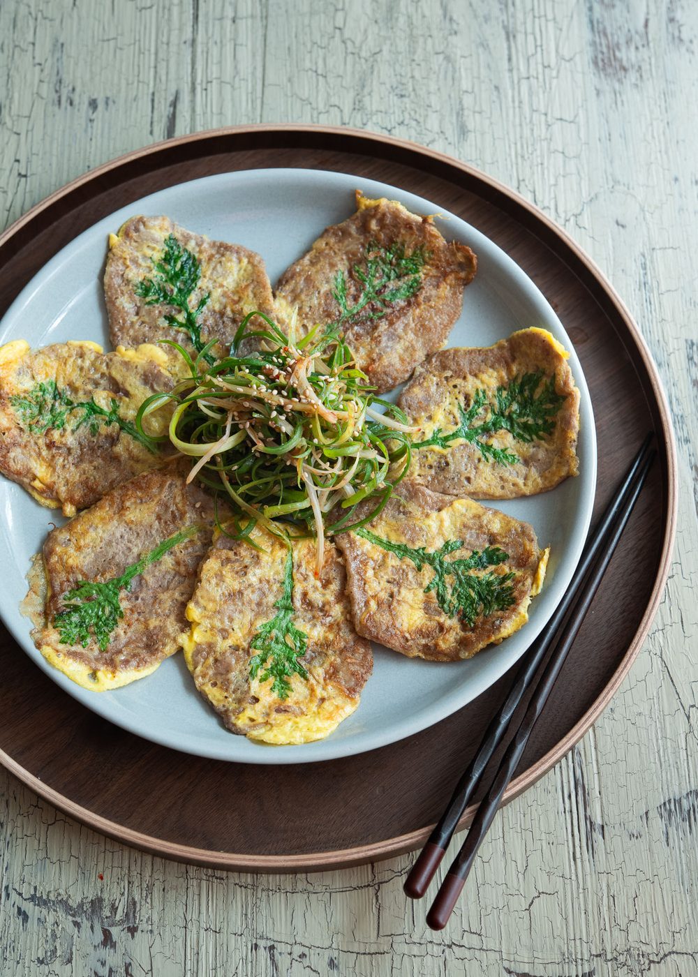 Yukjeon (Korean beef pancakes) are served with pachae salad