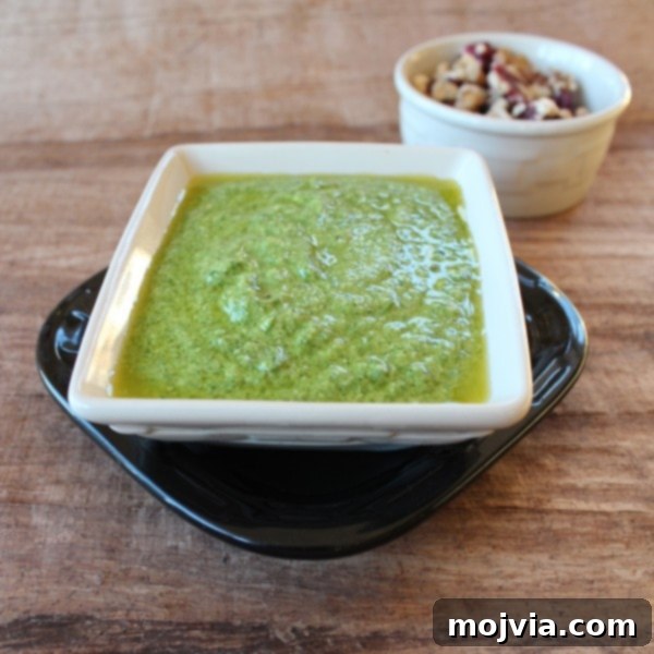 Robust Arugula Walnut Blue Cheese Pesto 3 A close-up of freshly made Arugula Walnut Blue Cheese Pesto in a food processor, showcasing its creamy texture.