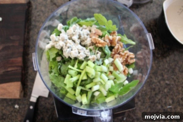 Robust Arugula Walnut Blue Cheese Pesto 5 All pesto ingredients (except olive oil) added to a food processor bowl.