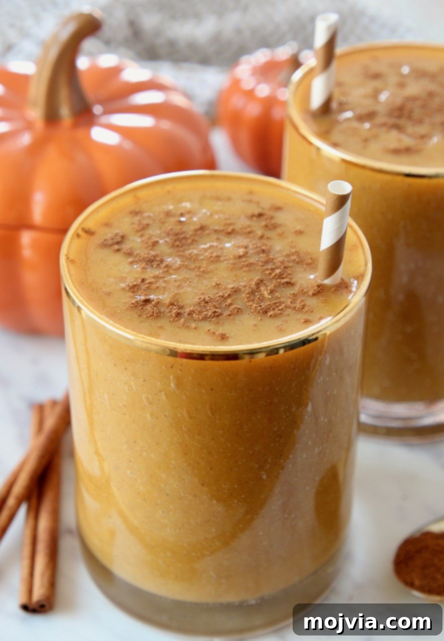 Autumn Glow Smoothie 2 A refreshing superfood pumpkin smoothie in a glass with a straw, ready to be enjoyed.