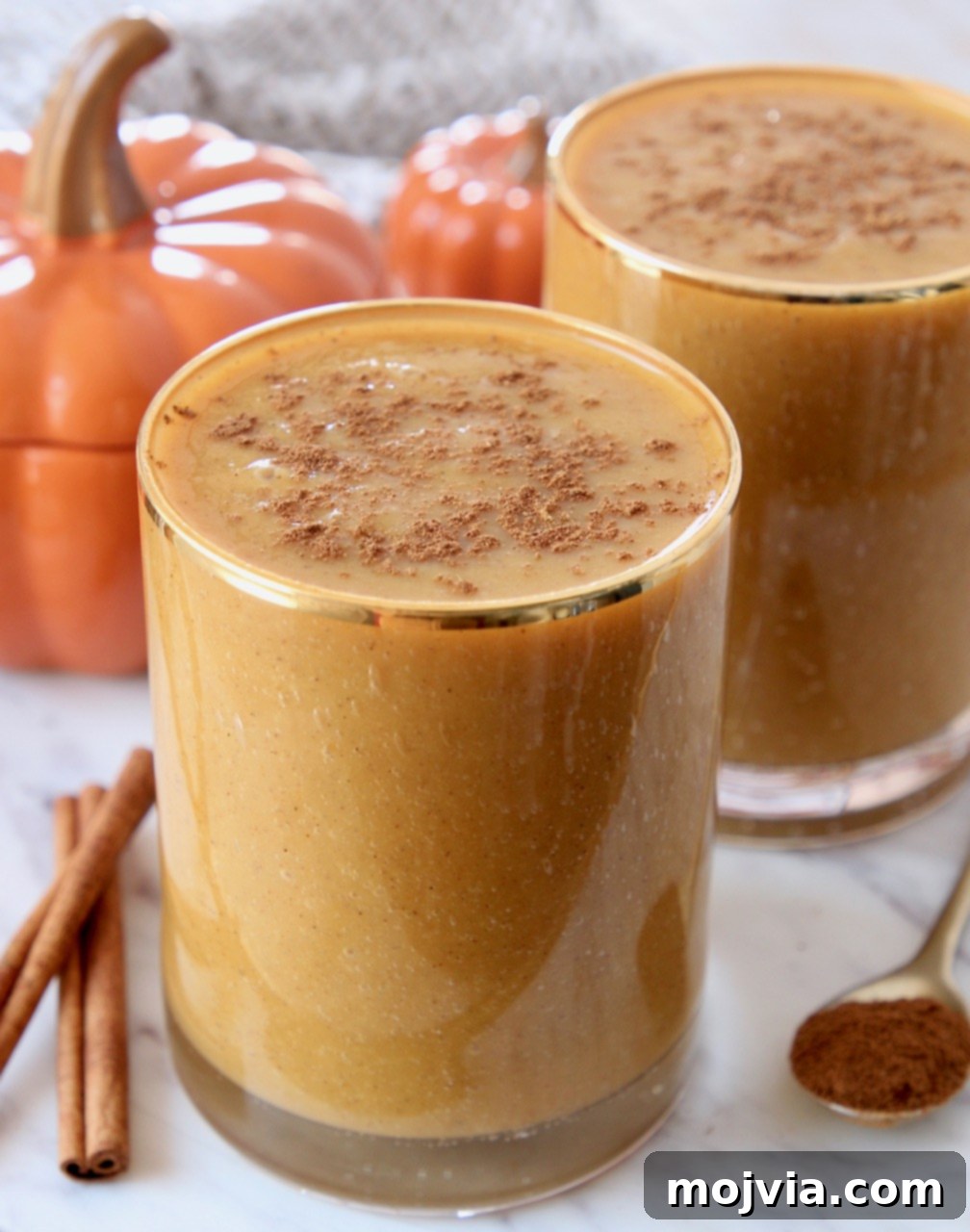 Autumn Glow Smoothie 5 A close-up shot of a creamy pumpkin banana smoothie in a clear glass, invitingly healthy and delicious.