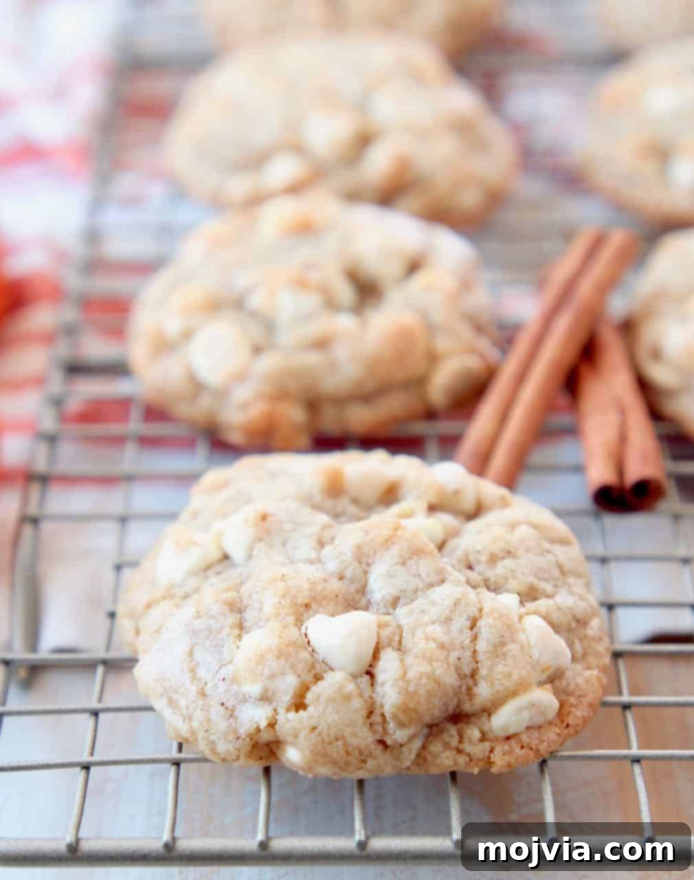 Autumn White Chocolate Pumpkin Delights 3 White chocolate chip cookies on wire baking rack with cinnamon sticks