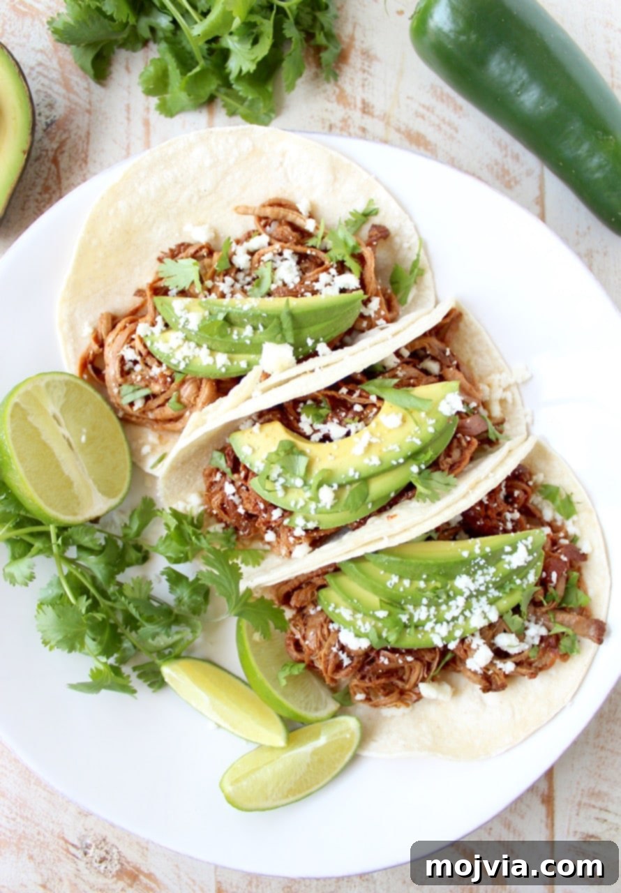 Melt-in-Your-Mouth Chipotle Honey Pulled Pork Tacos 8 Hand holding a fully dressed Slow Cooker Pulled Pork Tenderloin Chipotle Honey Taco
