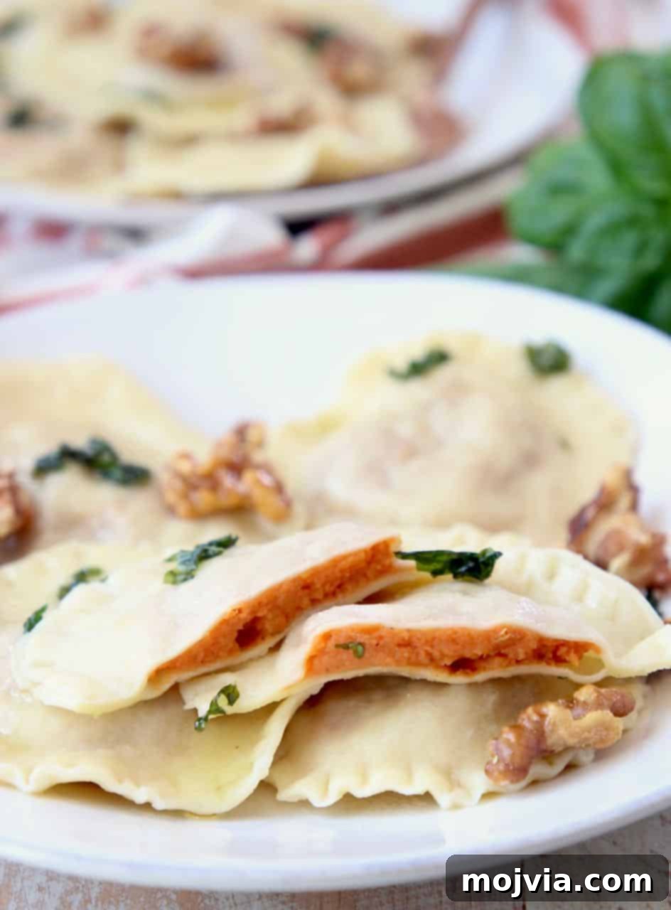 Golden Sweet Potato Ravioli 2 Sweet potato ravioli sliced in half on plate with whole raviolis and walnuts