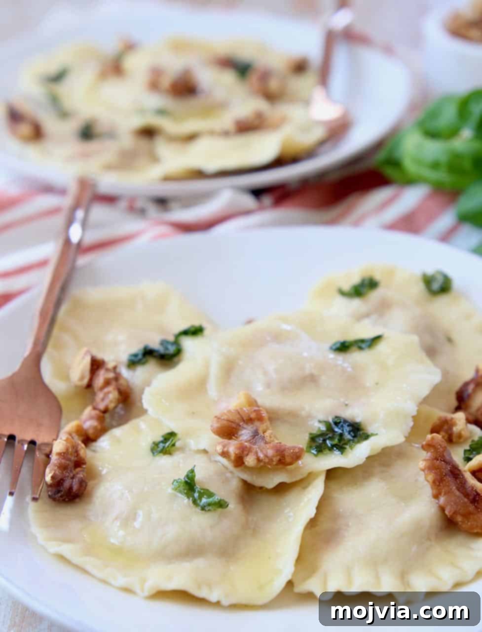 Golden Sweet Potato Ravioli 5 Raviolis on plate topped with basil brown butter sauce and toasted walnuts