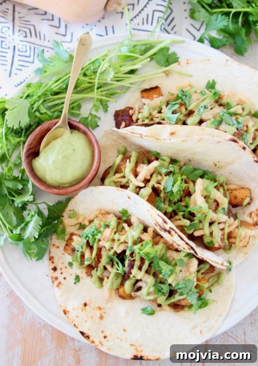 Roasted Butternut Squash Tacos 3 Butternut squash tacos topped with crispy onions, avocado cream sauce, and fresh cilantro served on flour tortillas