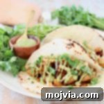 Butternut Squash tacos with creamy avocado sauce and fresh cilantro on flour tortillas