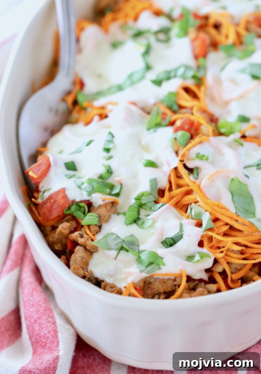 Tuscan Turkey Sweet Potato Bake 2 Italian turkey sweet potato casserole in oval baking dish with large serving fork, showcasing a healthy, gluten-free meal.