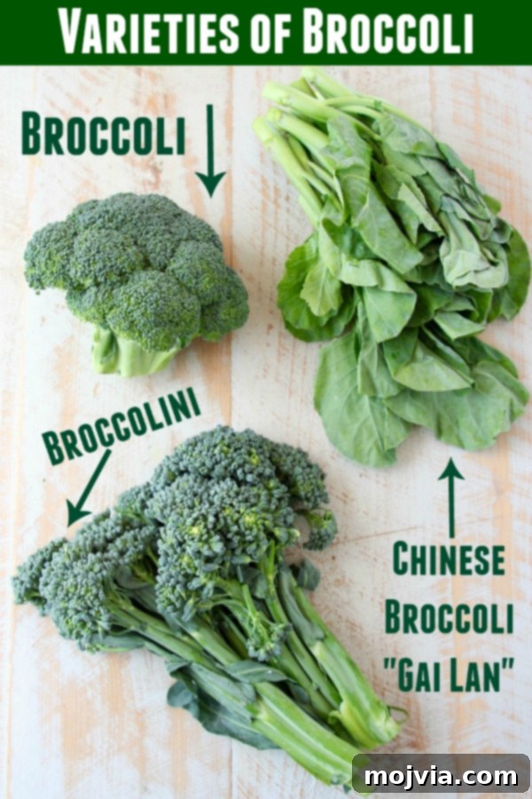 Broccoli, Chinese broccoli and broccolini displayed on white cutting board
