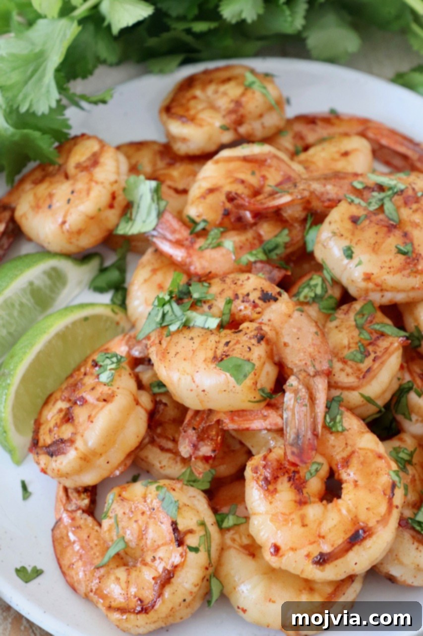 A generous pile of perfectly grilled shrimp, garnished with fresh cilantro, served hot off the grill.
