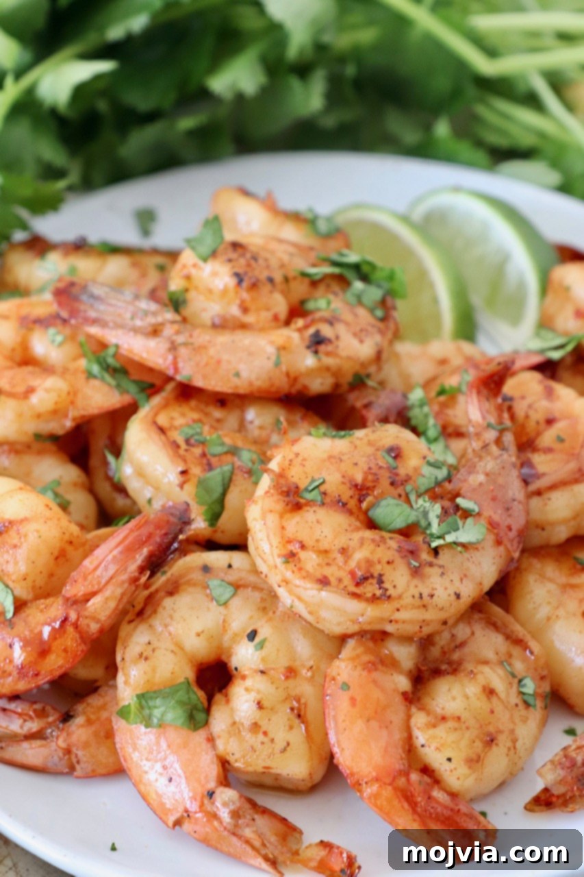 A beautifully arranged plate of grilled shrimp, accented with fresh lime wedges, ready to be served.