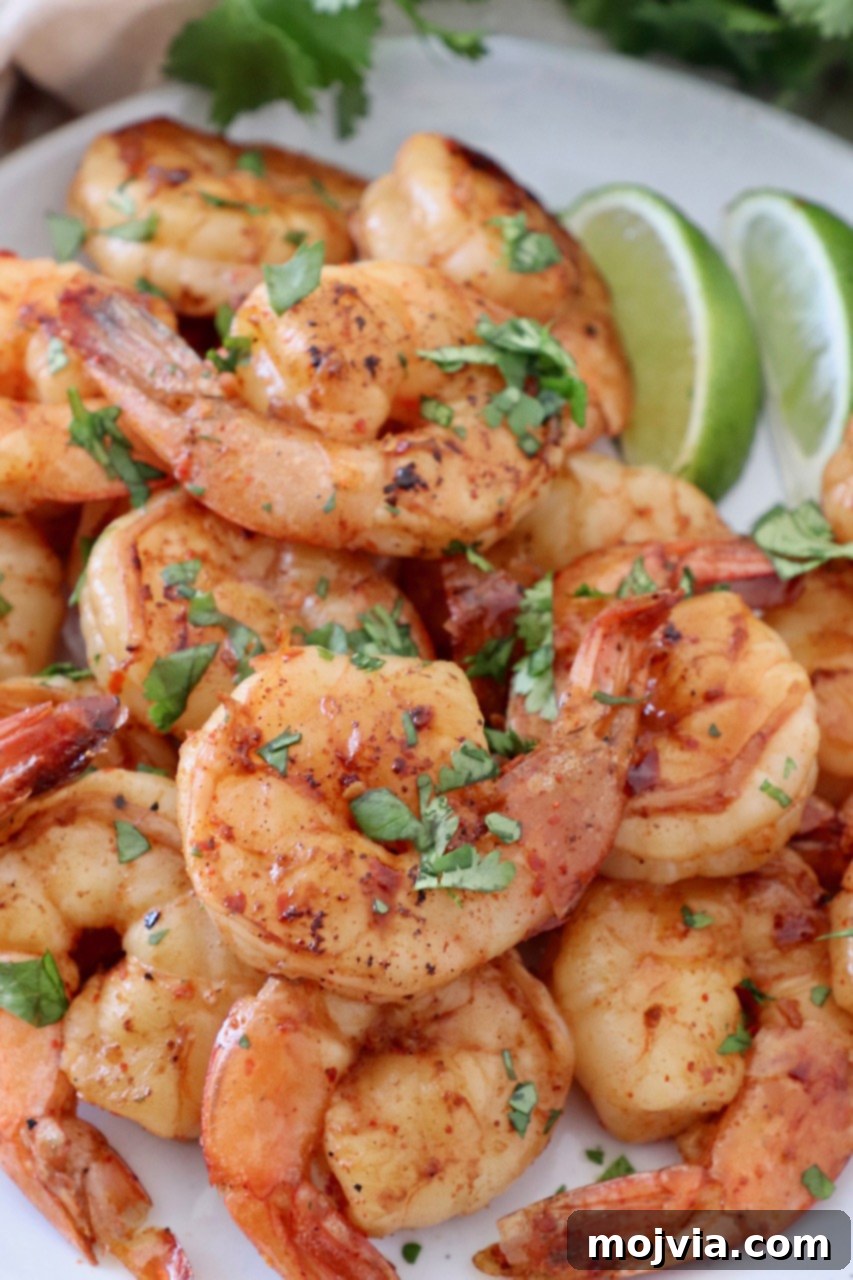 A serving of cooked, marinated shrimp presented on a plate with fresh cilantro garnish, ready to enjoy.