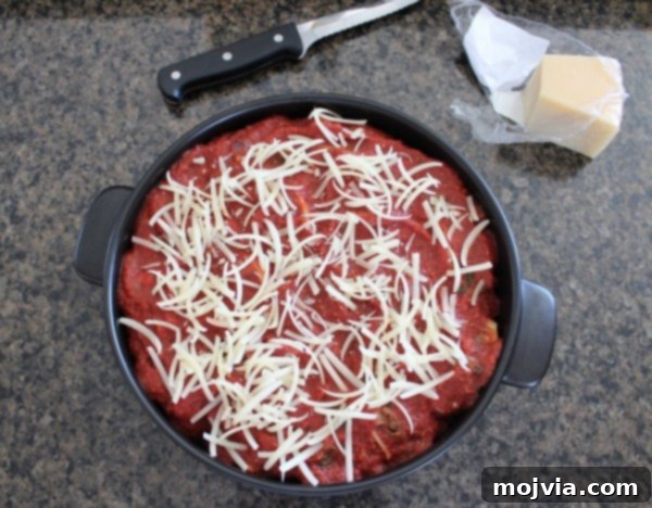 Sun-Drenched Sausage & Cheese Pasta Shells 11 An oven-safe pot generously filled with stuffed shells, luxuriating in a rich red sauce and crowned with a golden layer of Parmesan cheese, ready for baking.