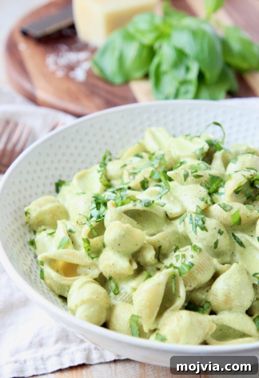 Vibrant Basil Pesto Pasta with Gooey Cheese 3 Cheesy pesto pasta shells in white bowl