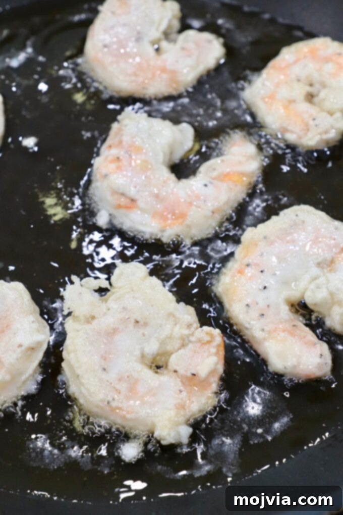 Golden Honey Walnut Prawns 7 battered shrimp cooking in oil in skillet
