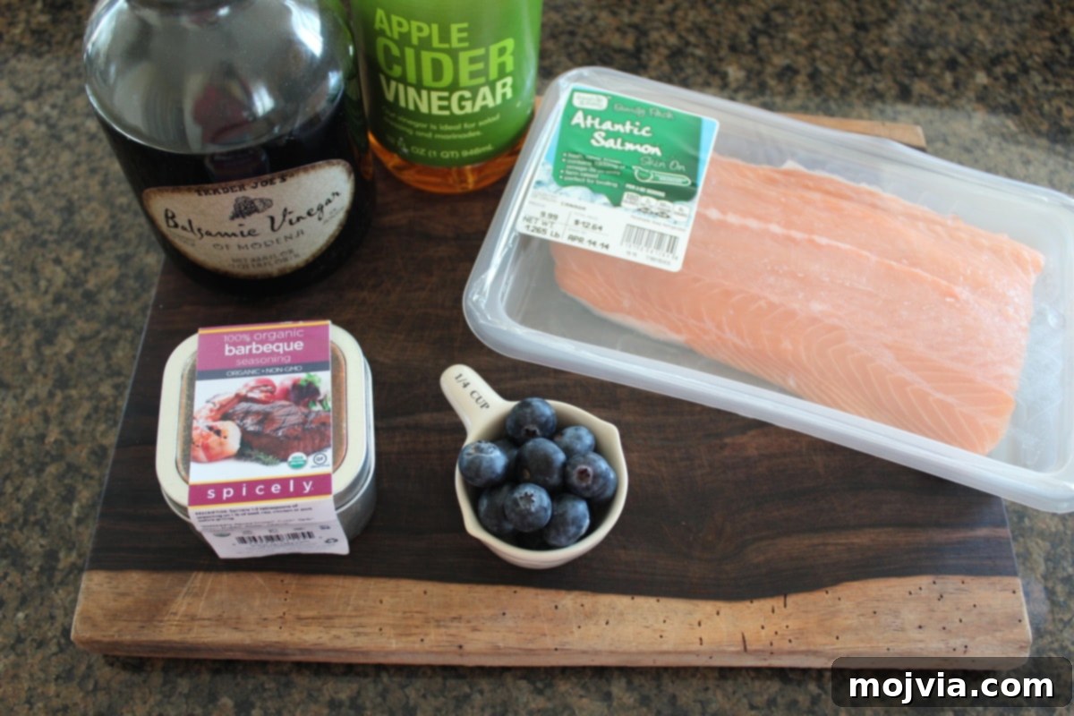 Blueberry BBQ Glazed Grilled Salmon 3 Blueberry BBQ Grilled Salmon Ingredients - Fresh blueberries, salmon, balsamic vinegar, apple cider vinegar, and BBQ seasoning laid out for the recipe.
