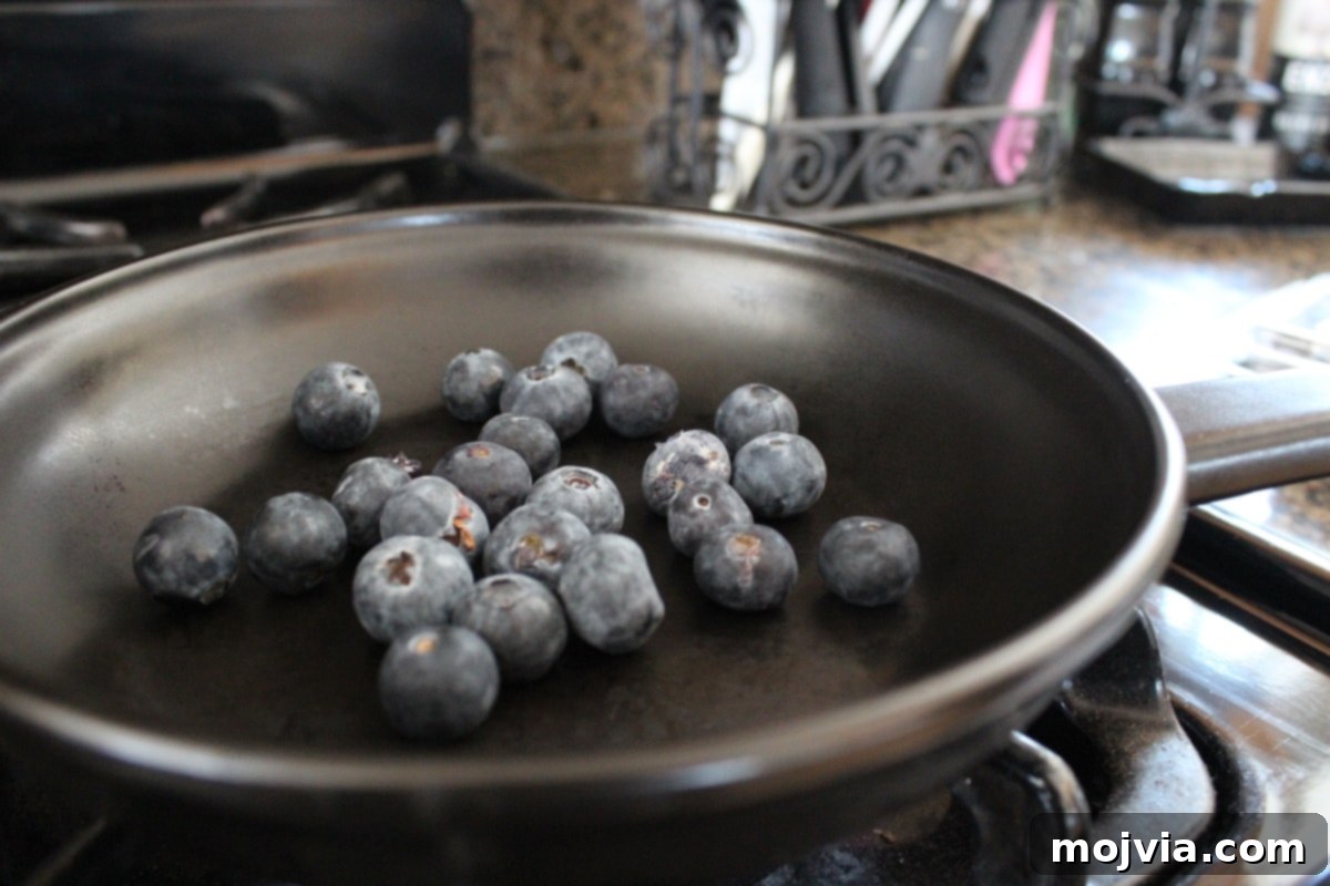 Blueberry BBQ Glazed Grilled Salmon 4 Blueberry BBQ Sauce Recipe - Fresh blueberries simmering in a saucepan with vinegars, starting to break down for the sauce.