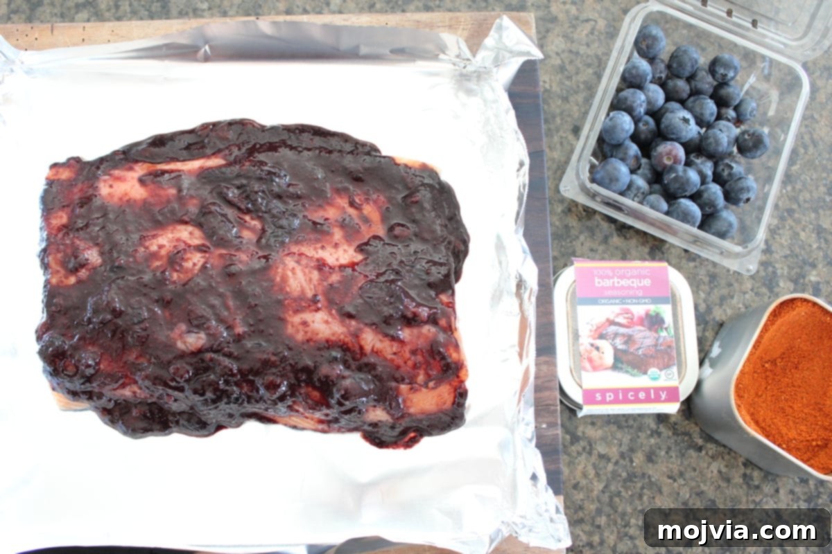 Blueberry BBQ Glazed Grilled Salmon 7 Blueberry BBQ Grilled Salmon Recipe - Salmon fillet in a foil basket, generously covered with blueberry BBQ sauce.