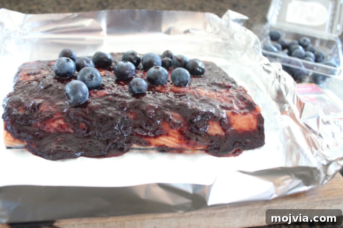 Blueberry BBQ Glazed Grilled Salmon 8 Blueberry BBQ Grilled Salmon Recipe - Remaining fresh blueberries sprinkled over the salmon and sauce in the foil basket.