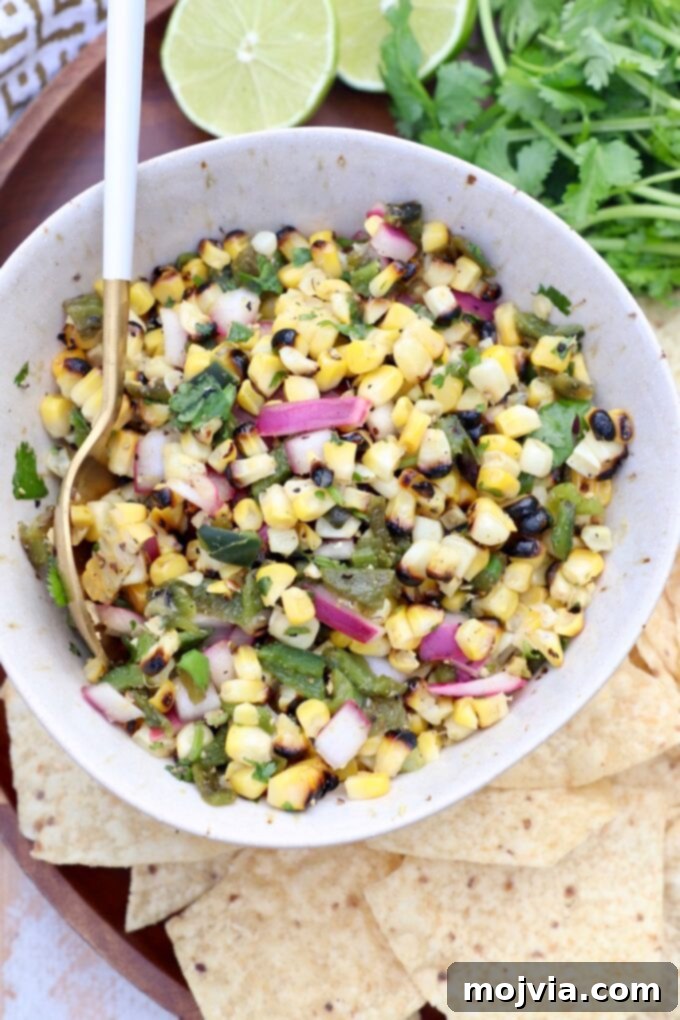 Fiesta Corn Salsa 6 A large white bowl filled with vibrant roasted corn and poblano pepper salsa, ready for serving.