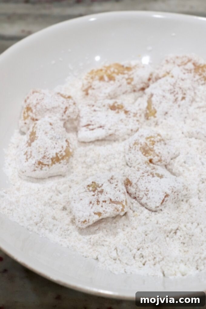 Zesty Gluten-Free Orange Chicken 6 Cornstarch-coated chicken pieces in a bowl