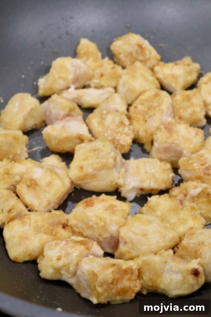 Zesty Gluten-Free Orange Chicken 7 Cooked breaded chicken pieces in a skillet