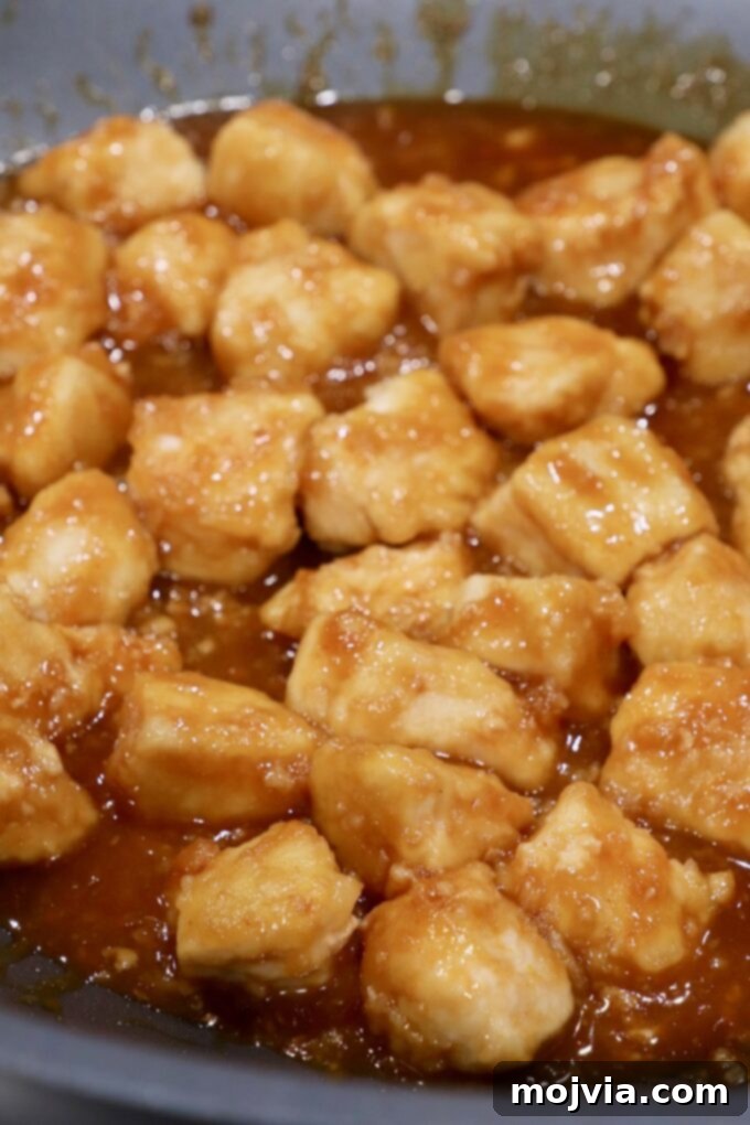 Zesty Gluten-Free Orange Chicken 9 Finished orange chicken simmering in the skillet
