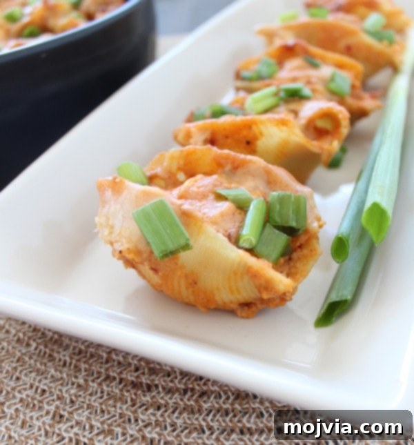 Close-up of baked Buffalo Chicken Alfredo Stuffed Shells in a baking dish.
