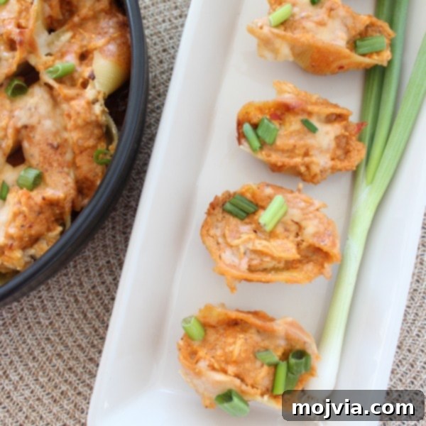 Assembling Buffalo Chicken Alfredo Stuffed Shells in a baking pan.