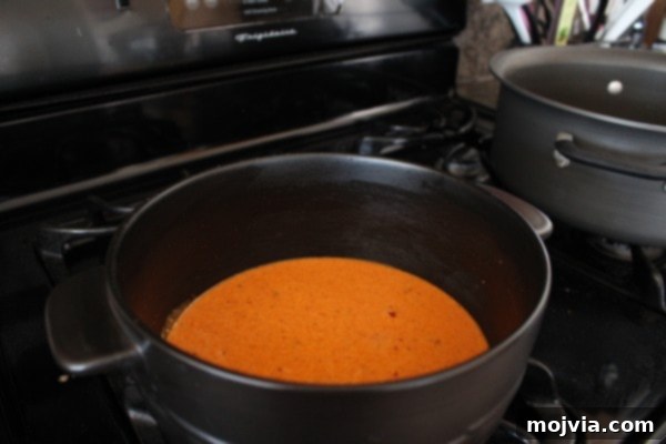 Whisking buffalo Alfredo sauce ingredients in a pot.