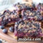 Blueberry oat bars, sliced into squares on a wood cutting board.