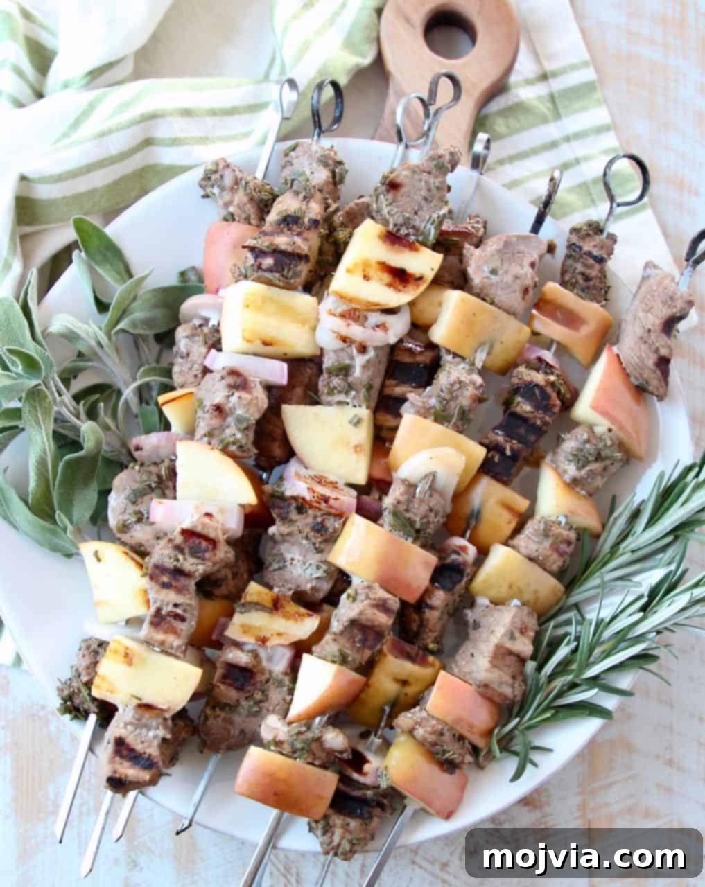 Fragrant Rosemary Sage Pork Skewers 2 Stacked grilled pork skewers with fresh herbs, ready to serve
